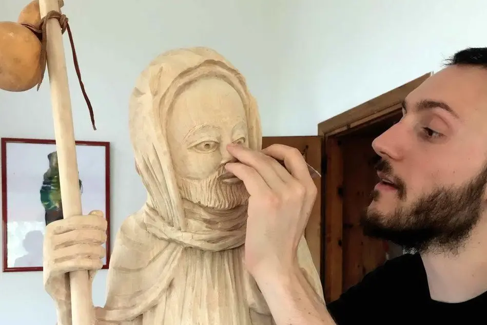 L'artista Carlo Spiga dipinge la statua di San Giacomo