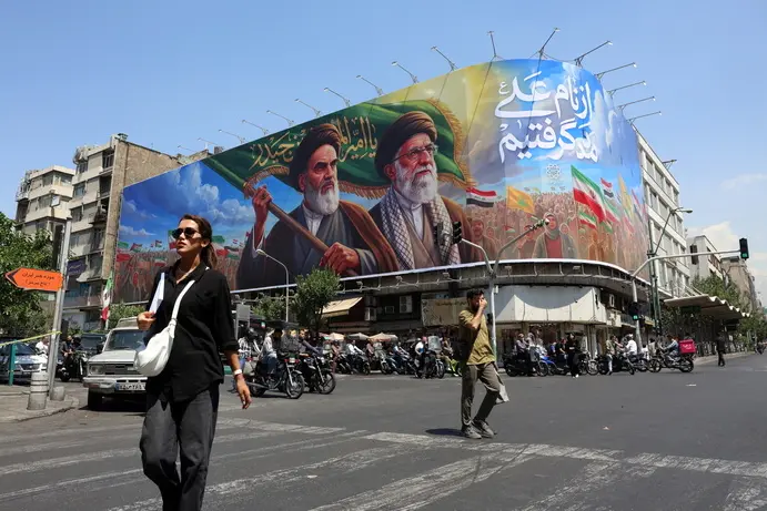 epa13027709 Iranians walk past a large billboard featuring late Iranian Supreme Leader Ayatollah Ruhollah Khomeini and Supreme Leader Ayatollah Ali Khamenei on a street in Tehran, Iran, 10 June 2026. According to US Central Command (CENTCOM), self-defense strikes were carried out against Iran near the Strait of Hormuz on 09 June in response to the downing of a US Army Apache helicopter. EPA/ABEDIN TAHERKENAREH RESTRICTIONS: NO Access Israel Media/Persian Language TV Stations Outside Iran/Strictly No Access BBC Persian/VOA Persian/Manoto TV/Iran International TV. (As mandated by Iran's Directorate General for Foreign Media) --