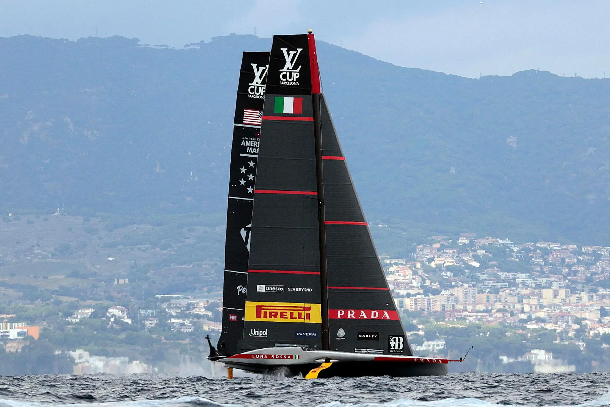 epa11612310 Luna Rossa Prada Pirelli of Italy and NYYC American Magic of US (L) compete on the fourth day of the Louis Vuitton Cup Semi-Finals within the America's Cup sailing competition, in Barcelona, Spain, 18 September 2024. EPA/TONI ALBIR