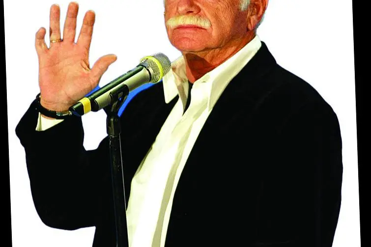 Gino Paoli sul palco del teatro Ariston a Sanremo mostra ai fotografi il premio alla carriera il 3 marzo 2004. CLAUDIO ONORATI/ANSI / ANSA-CD