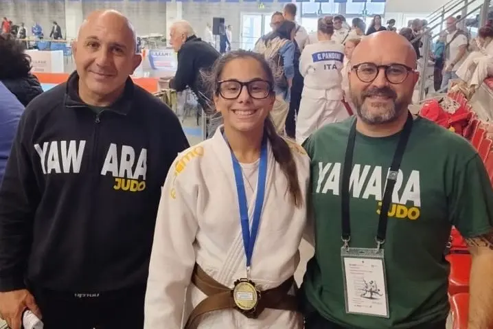 Beatrice Melis con i maestri Marco Mascia (a sinistra) e Andrea Sitzia (a destra) dopo la vittoria a Riccione