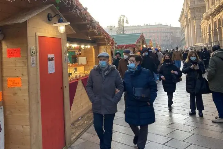 Passanti in centro a Milano (Foto L'Unione Sarda)