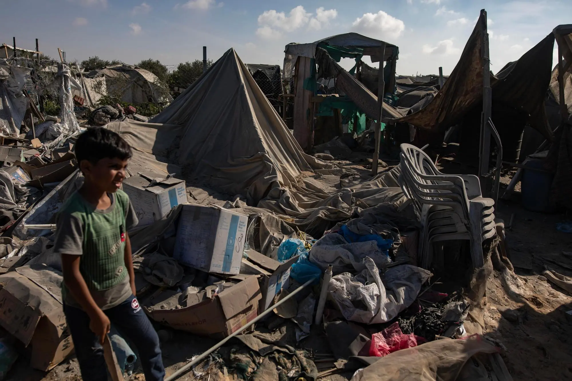 Un bambino palestinese accanto alla devastazione (Ansa)