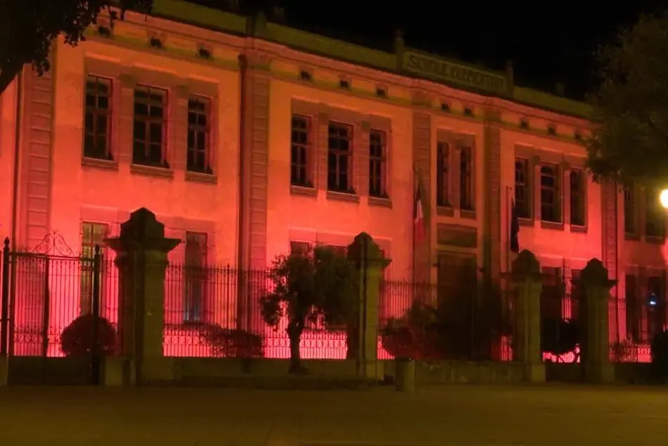 La facciata del Comune illuminata di rosa