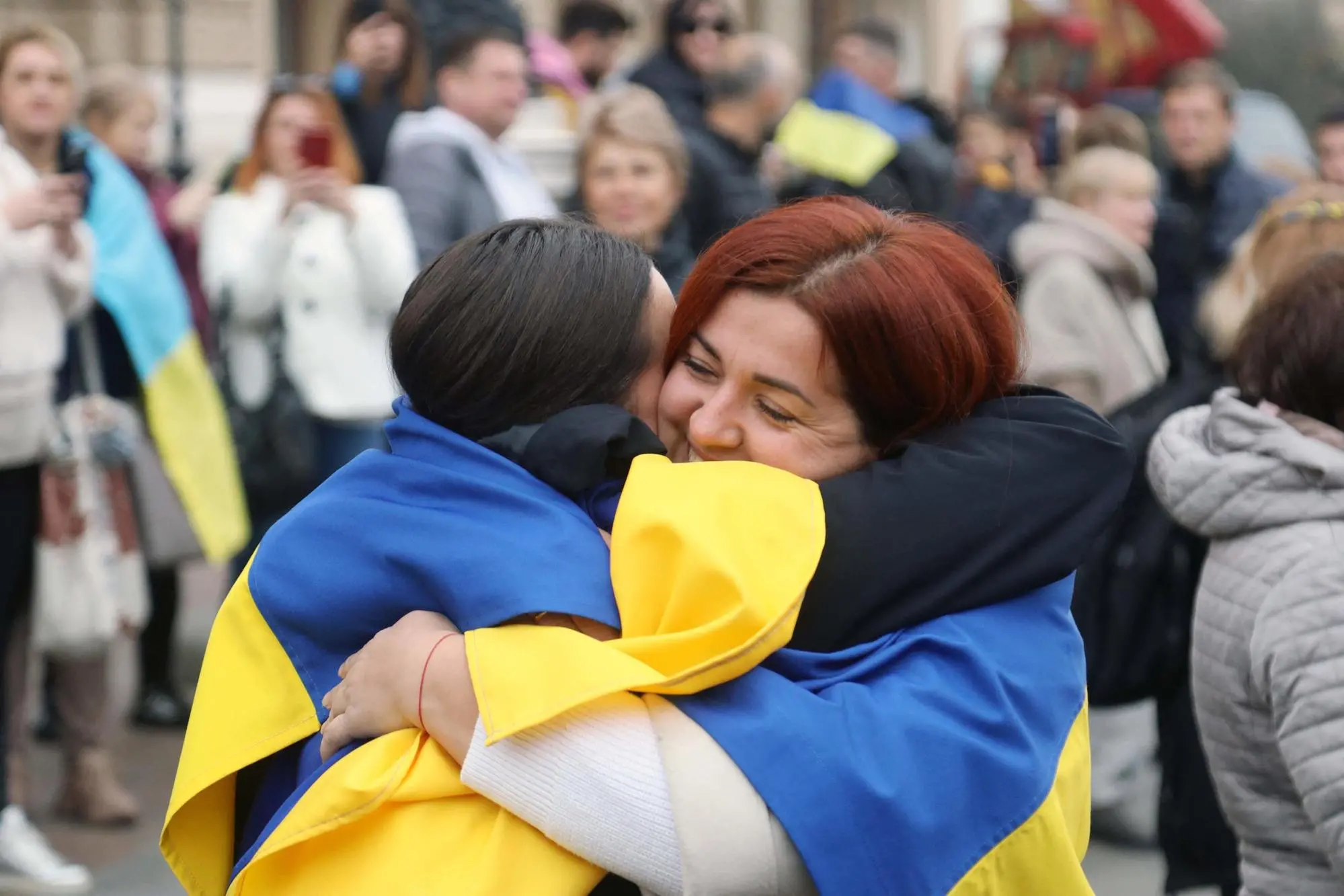 Residents of Kherson temporarily living in Odessa, wearing Ukrainian flags, celebrate the liberation of their native town in front of The Odessa National Academic Opera and Ballet Theatre in Odessa, on November 12, 2022, amid Russia's invasion of Ukraine. - Ukrainian President Volodymyr Zelensky declared Kherson "ours" after Russia withdrew troops from the city, which the US hailed Saturday as an "extraordinary victory". (Photo by Oleksandr GIMANOV / AFP)