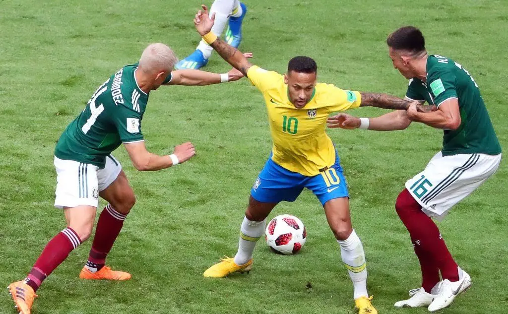 Il numero dieci del Brasile Neymar pressato da due messicani