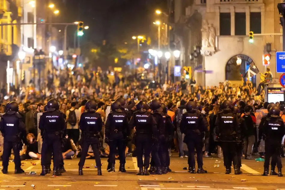 La polizia fronteggia i manifestanti a Barcellona (Ansa)