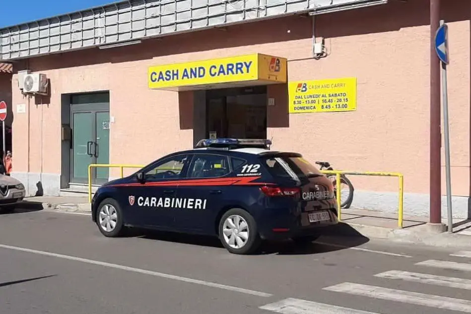 Carabinieri davanti al supermercato in cui è avvenuto il furto (foto L'Unione Sarda)