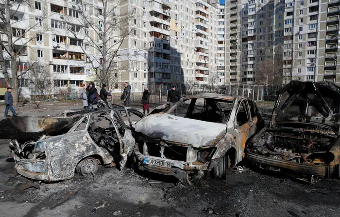 Auto distrutte in una strada di Kiev (Ansa)