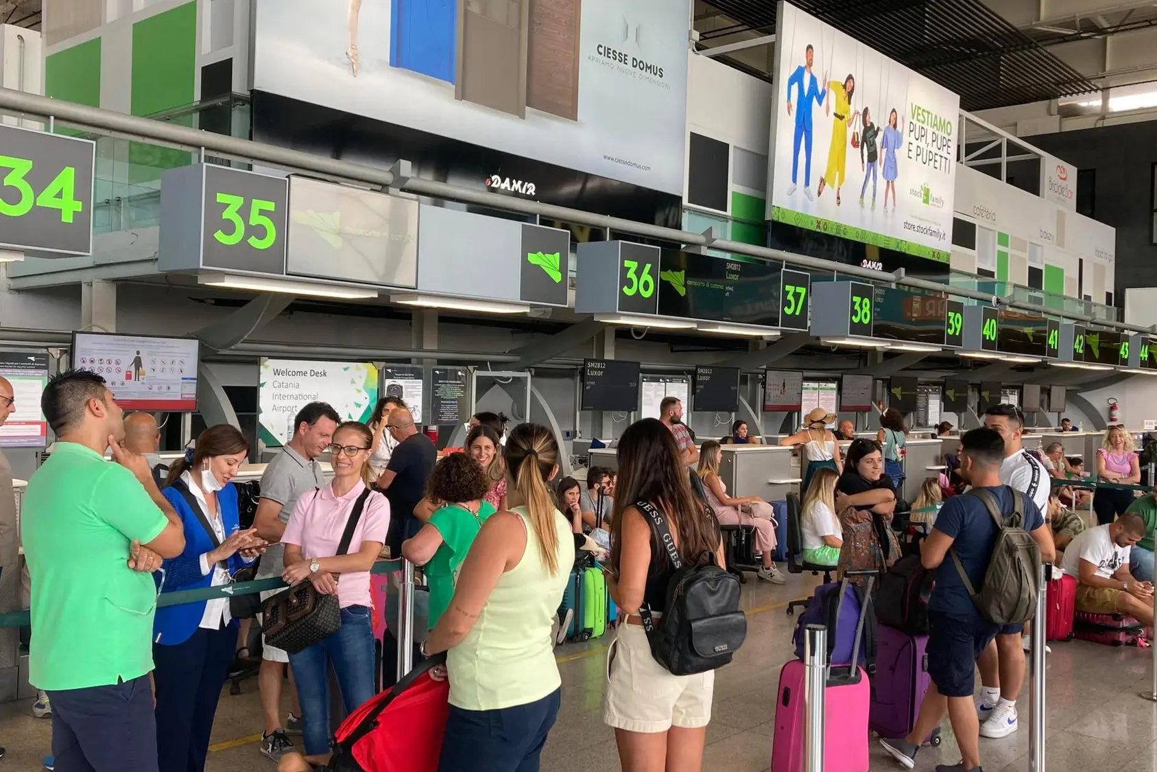 Viaggiatori e turisti all'aeroporto di Catania (Ansa)