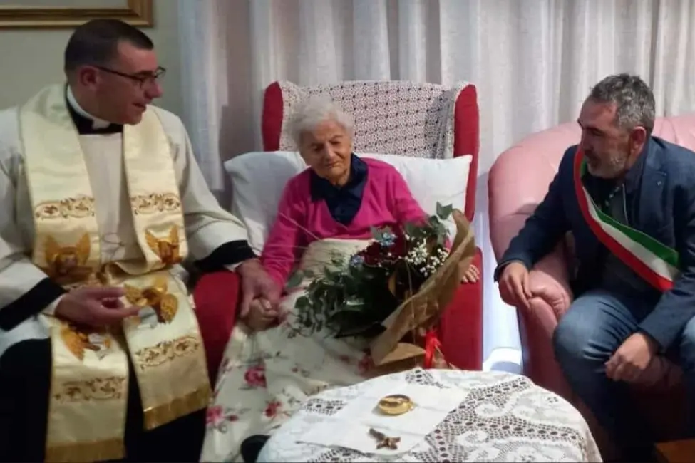 Angela Serra festeggiata dal parroco, don Battista Mura, e dal sindaco, Giulio Murgia (foto concessa)