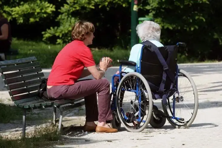 Una badante al parco con un'anziana