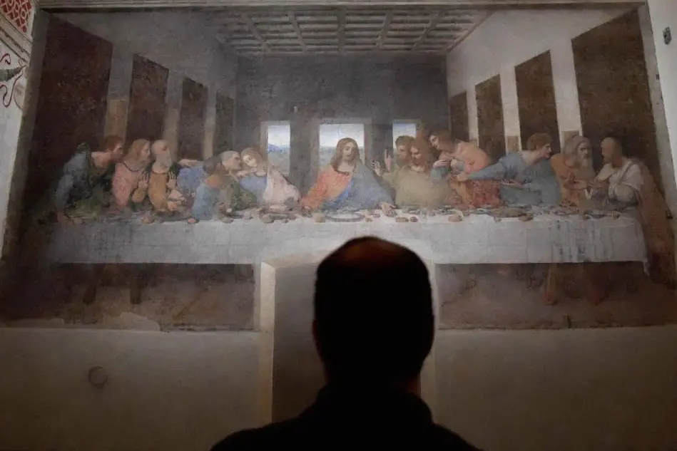 Un visitatore intento ad osservare il Cenacolo di Leonardo da Vinci (Ansa)