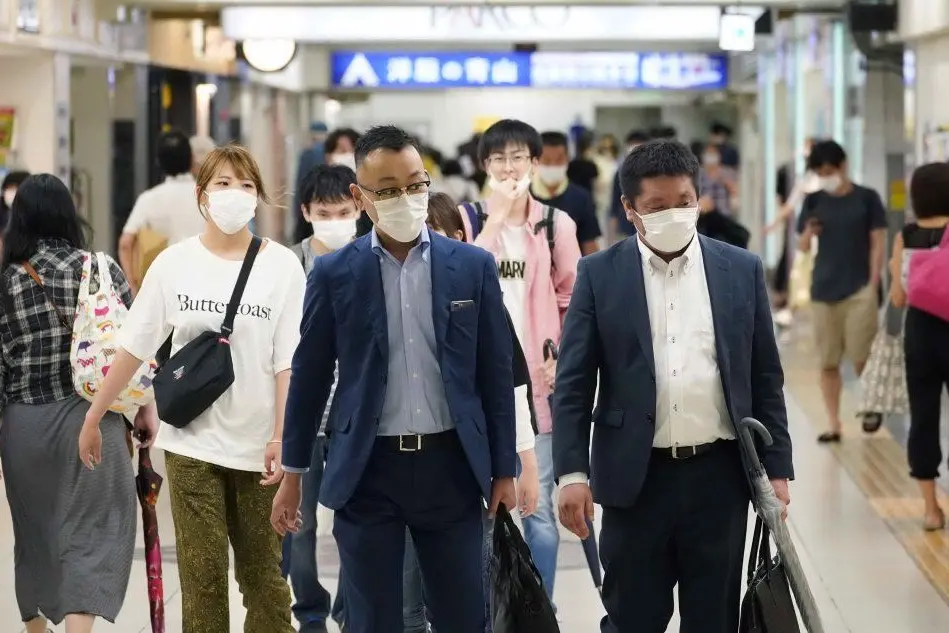 Viaggiatori a Tokyo (foto Ansa/Epa)