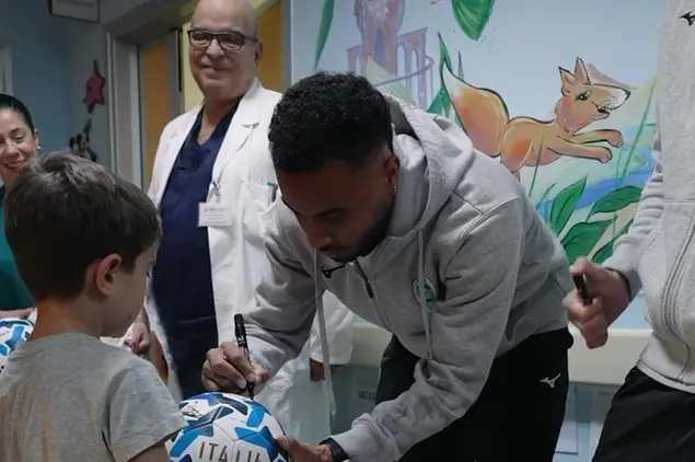 Capitan Arboleda firma un pallone a un bambino della Pediatria (foto Olbia Calcio)