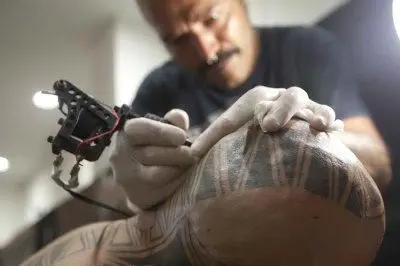 Un tatuatore al lavoro