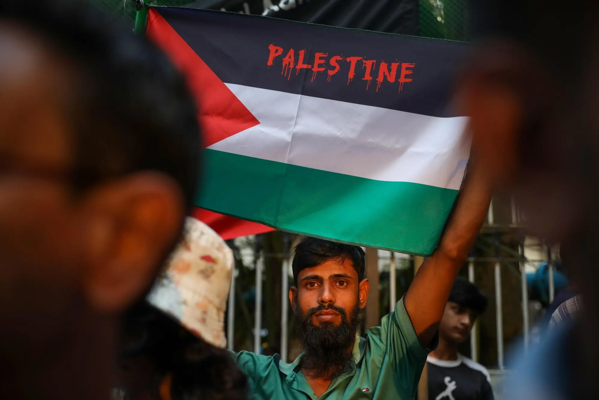 epa12439971 A man holds a Palestinian flag as supporters of Ganosanhati Andolan political party take part in a rally in support of the Palestinian people and activists of the Global Sumud Flotilla in Dhaka, Bangladesh, 08 October 2025. The protesters are demanding the release of all rights activists, including Bangladeshi photographer and activist Shahidul Alam, who was detained by Israeli forces. EPA/MONIRUL ALAM