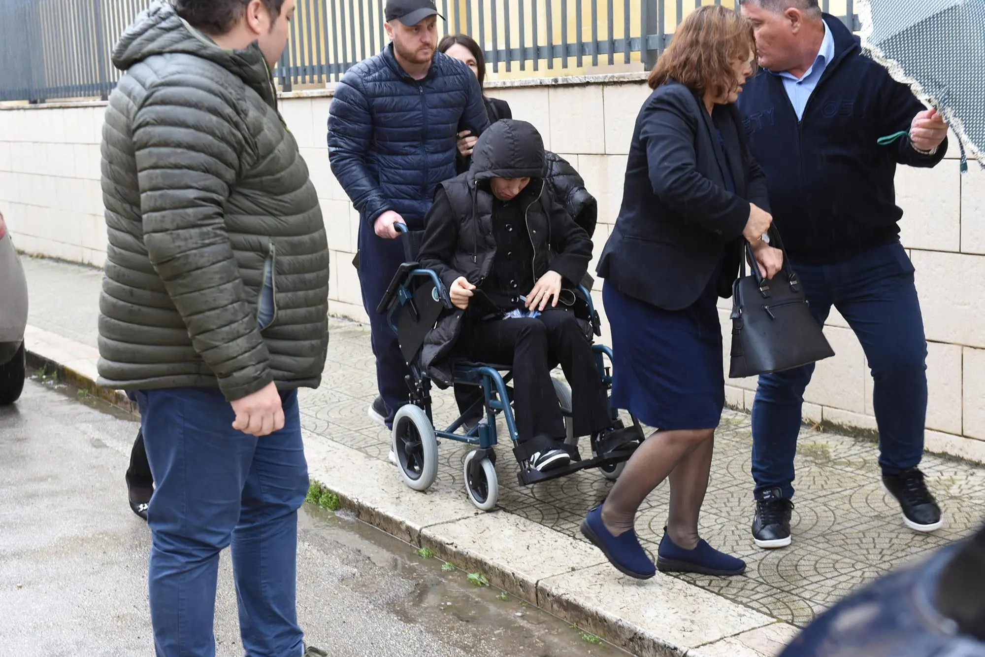 Tefta Malaj, in sedia a rotelle, nel giorno dei funerali della figlia (Ansa)