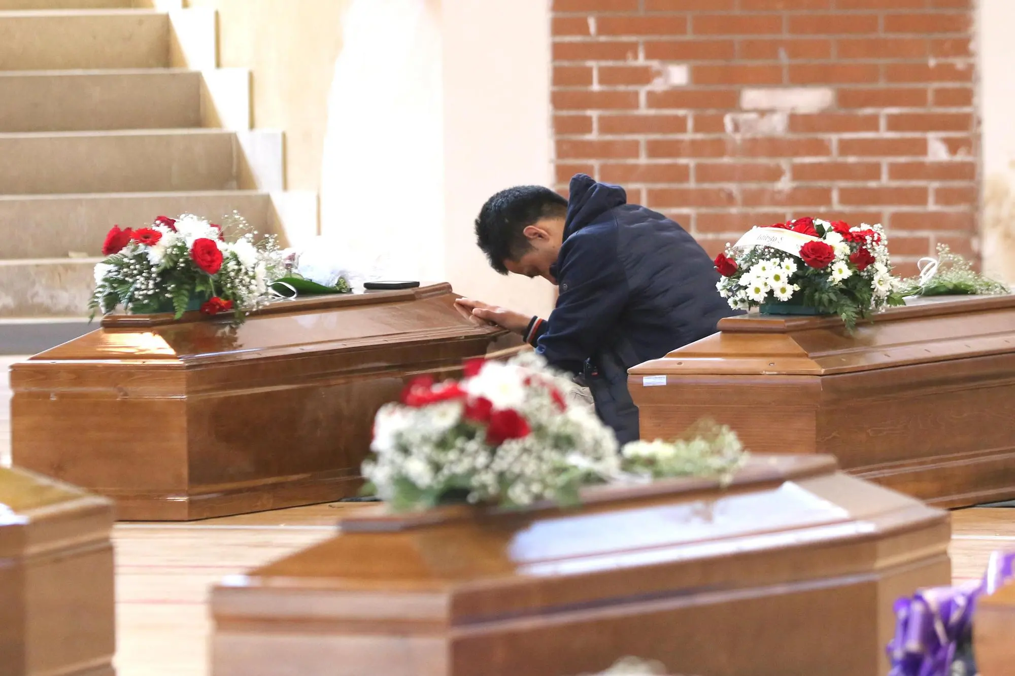 The relatives of the victims of the Steccato di Cutro shipwreck mourn over the coffins of their loved ones in the Crotone sports hall where the funeral home has been set up, in Crotone, Italy, 02 March 2023. At least 67 migrants died after their overloaded boat sank early on 26 February 2023 in stormy seas off Italy's southern Calabria region. ANSA/ SALVATORE MONTEVERDE
