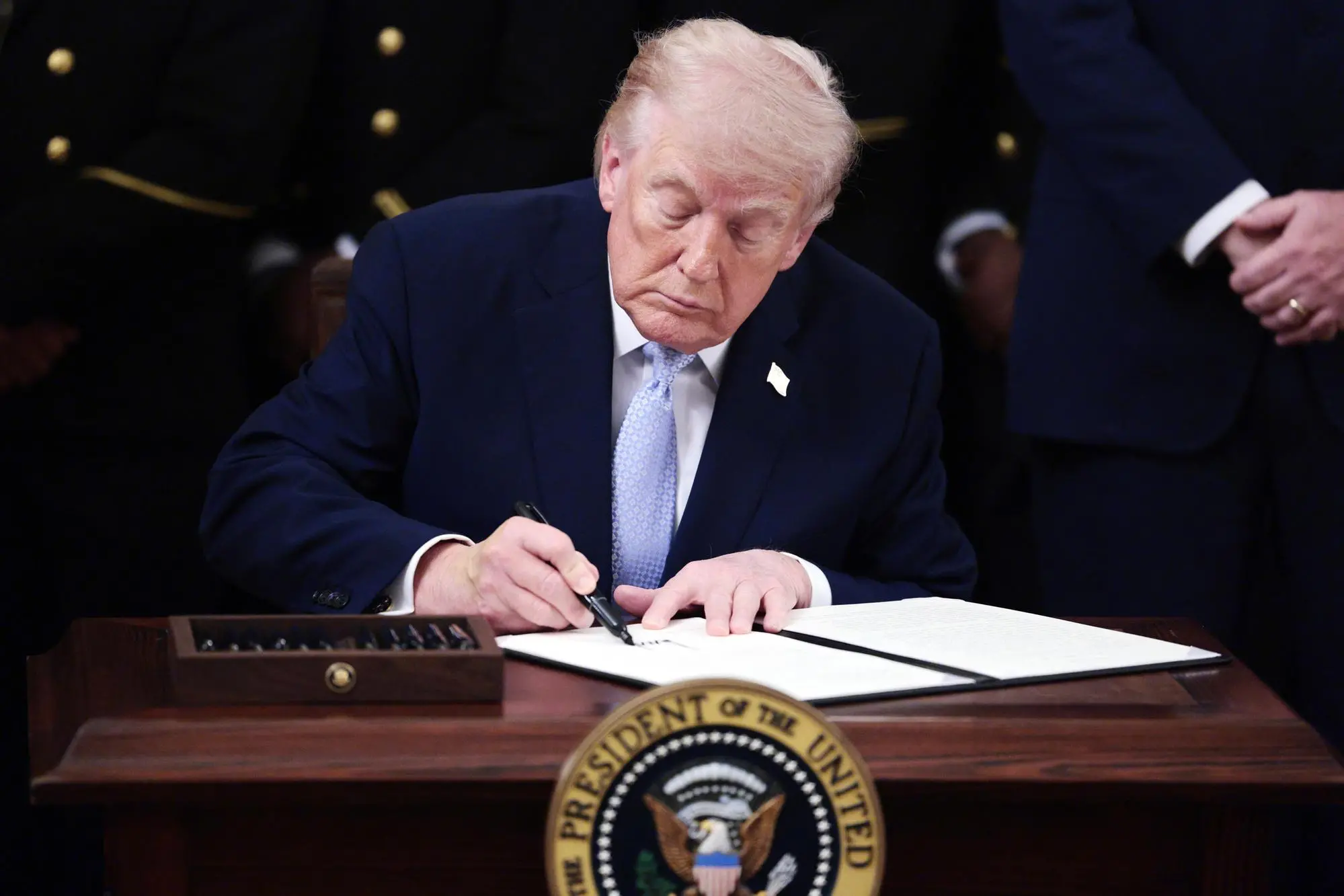 epaselect epa12836645 US President Donald Trump signs an executive order during the Commander in Chief Trophy Presentation at the White House, Washington, DC, USA, 20 March 2026. EPA/SHAWN THEW / POOL
