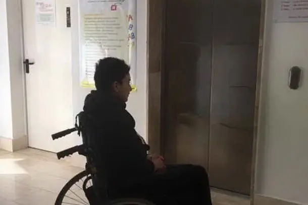 La donna malata davanti all'ascensore guasto