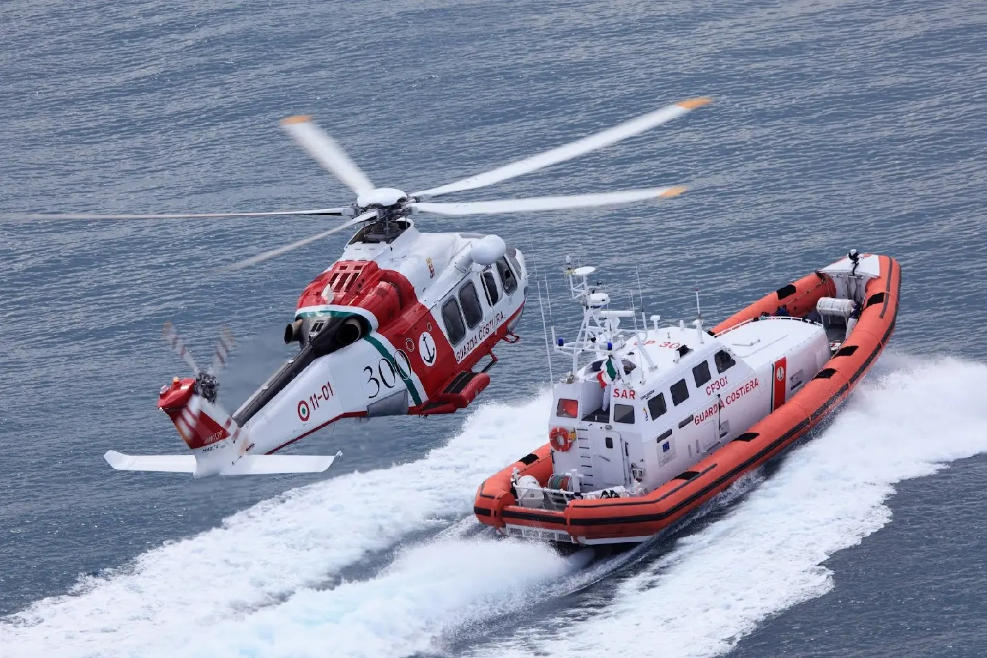 Una motovedetta e un elicottero della Guardia costiera  (L'Unione Sarda)