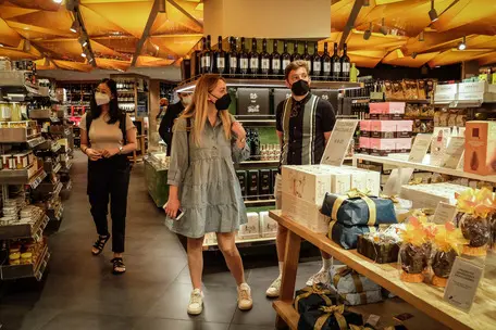 Gente con mascherine e senza in negozi e luoghi al chiuso il primo giorno delle nuove regole covid in cenrto a Milano, 2 Maggio 2022.ANSA/MATTEO CORNER