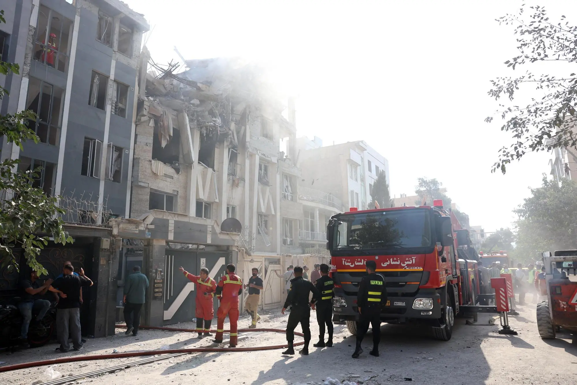 epa12172799 Fire fighters, rescue workers and security personnel work around a building that was hit by Israeli air strikes in central Tehran, Iran, 13 June 2025. Israel confirms it has launched strikes on Iran's 'nuclear program' as blasts are heard across the country. The strikes are part of Operation Rising Lion, Israel's Prime Minister Benjamin Netanyahu said, adding Iran was a threat to "Israel's very survival". EPA/ABEDIN TAHERKENAREH