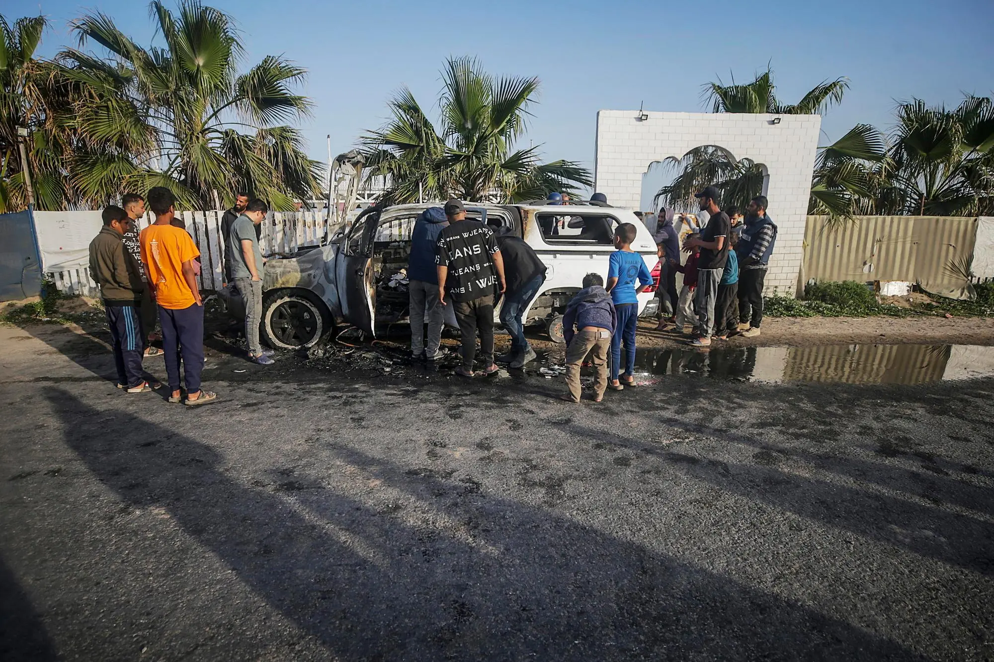 L'auto distrutta degli operatori umanitari (foto Ansa/Epa)