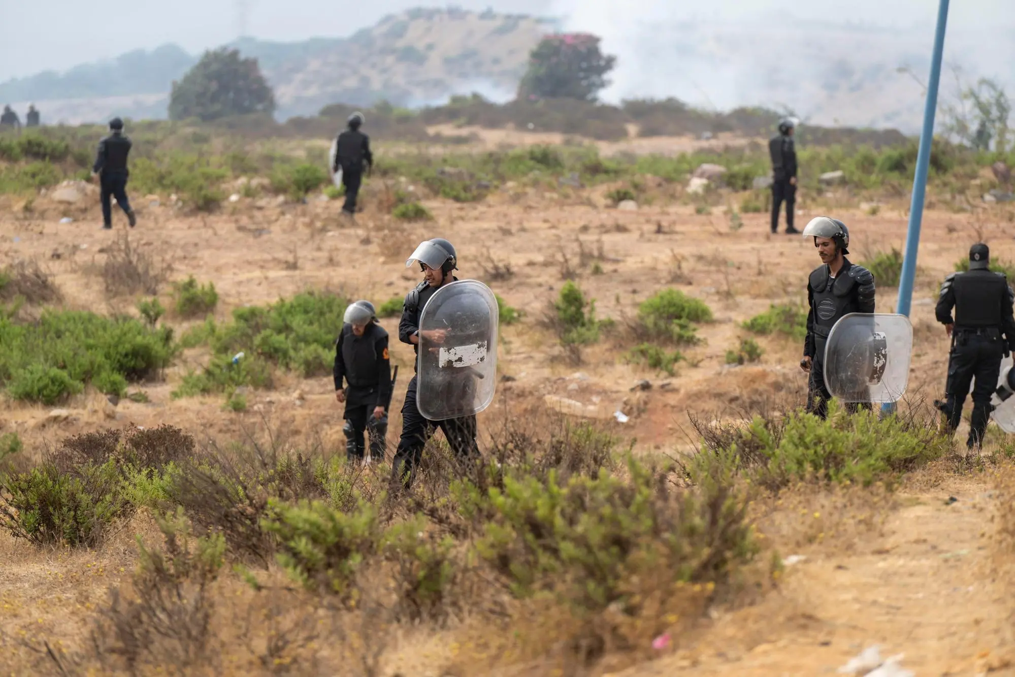 epa13143851 Members of the Moroccan security forces gather at the site of clashes at the Bab Sebta border crossing near Fnideq, Morocco, 31 July 2026. The unrest erupted as thousands of migrants attempted to cross into Ceuta and clashed with Moroccan security forces. EPA/JALAL MORCHIDI