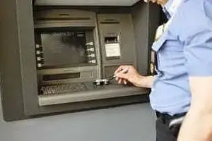 Un carabiniere davanti a uno sportello bancomat