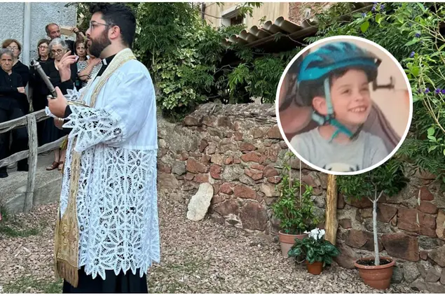 Don Marco Congiu benedice la scultura lignea (foto parrocchia Urzulei). Nel riquadro il piccolo Mattia (Archivio L'Unione Sarda)