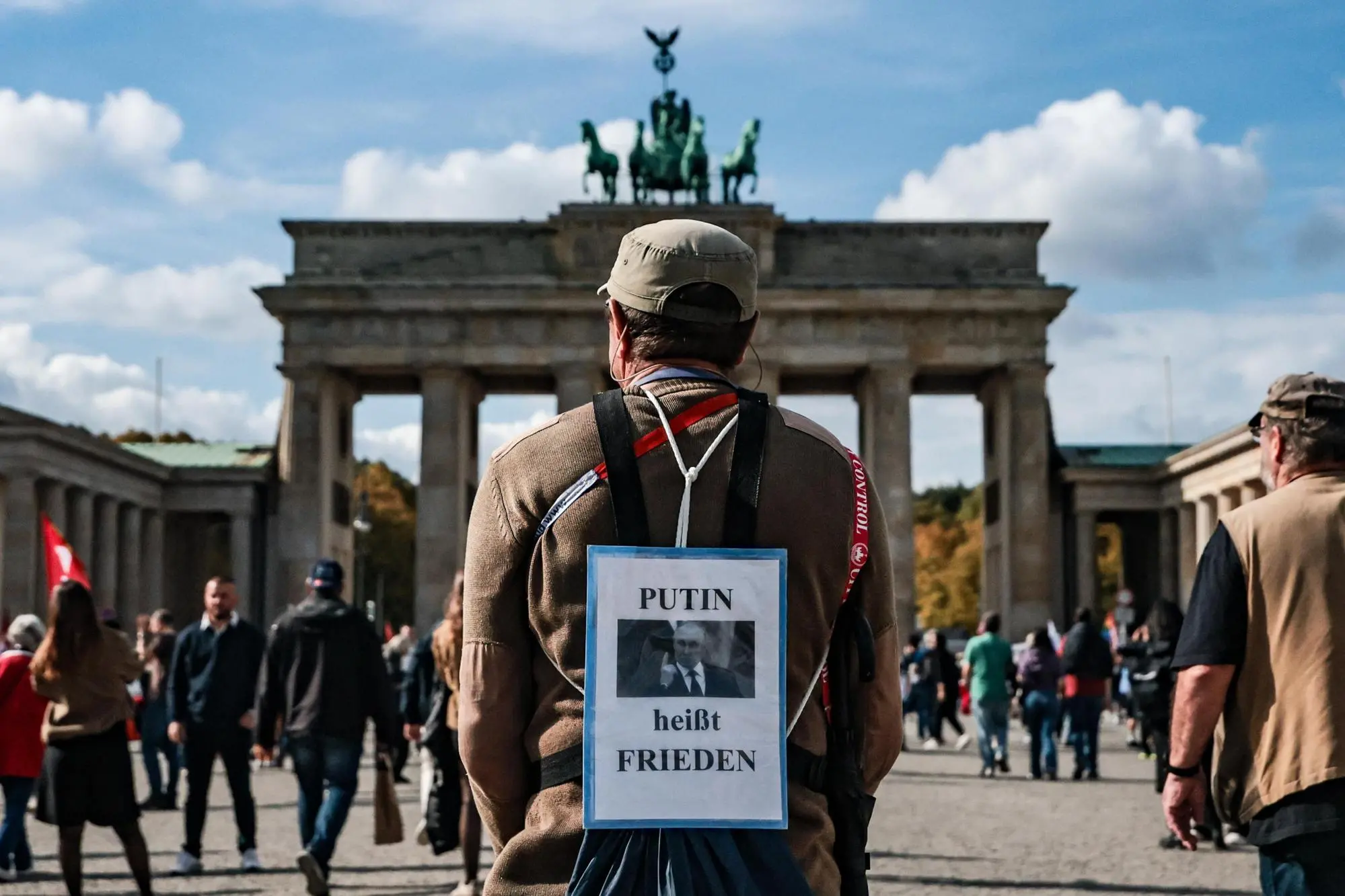 Un manifestante pro Putin davanti alla Porta di Brandeburgo (Ansa)
