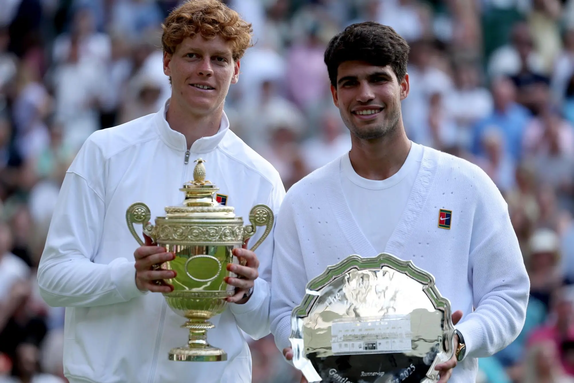 epa12236193 Jannik Sinner of Italy (L) celebrates with the trophy after winning the Men's Singles final match against Carlos Alcaraz of Spain with his runner-up trophy at the Wimbledon Championships, Wimbledon, Britain, 13 July 2025. EPA/NEIL HALL EDITORIAL USE ONLY