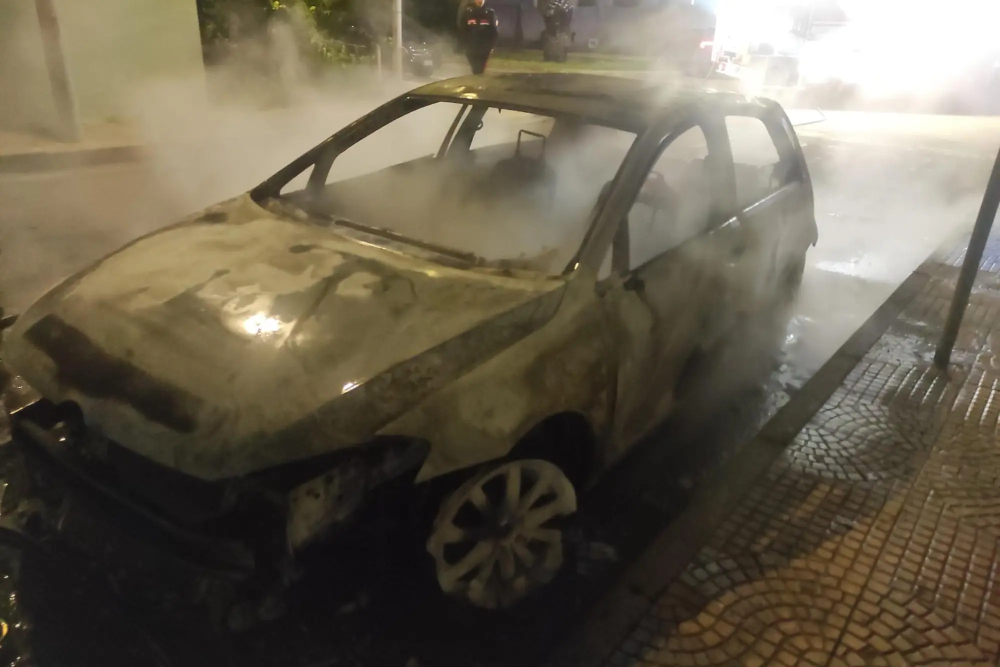 L'auto distrutta dalle fiamme a Torregrande (foto Pinna)