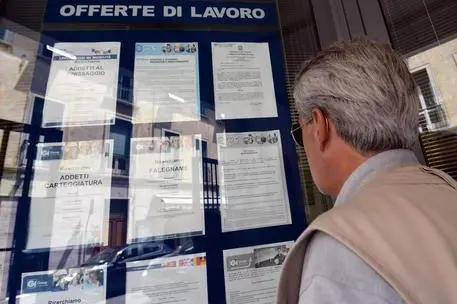 Un uomo controlla gli annunci di lavoro esposti in una agenzia per l'occupazione a Pisa. ANSA/FRANCO SILVI