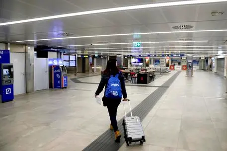 One of the last departing passengers walks inside Milan's Linate cityairport which is semi-deserted due to the coronavirus emergency, MIlan, Italy, 13 March 2020. One of the last departing passengers walks inside Milan's Linate airport which is semi-deserted due to the coronavirus emergency. the entire Milan Linate airport was temporarily closed. In order to minimize the number of people involved in operational activities to protect the health of all and according to the provisions of the Decree issued today by the Ministry of Transport, commercial and general aviation passenger traffic will be concentrated on Milan Malpensa airport. ANSA/Mourad Balti Touati