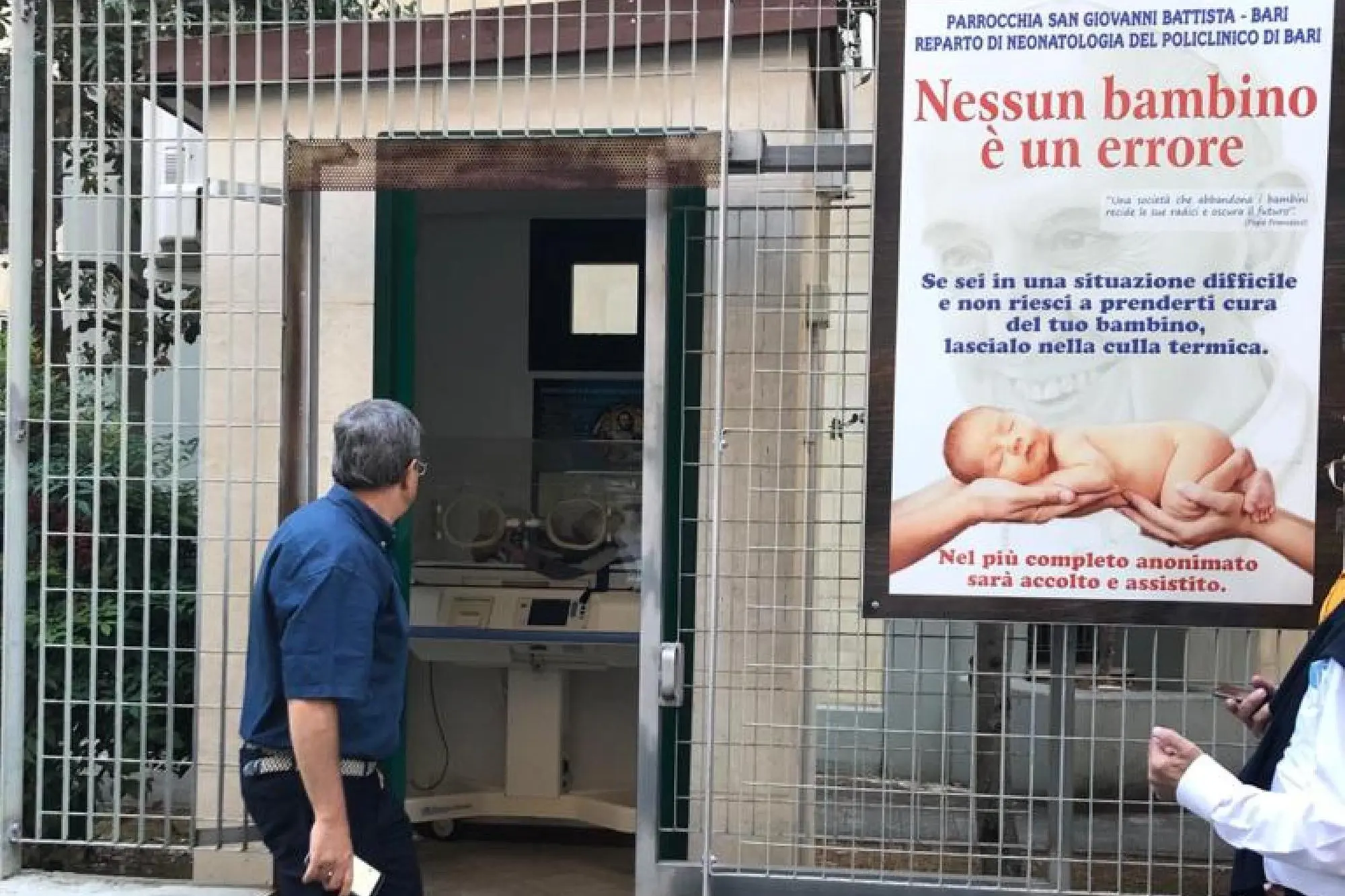 Don Antonio Ruccia di fronte all'ingresso del locale in cui si trova la culla (foto Ansa)