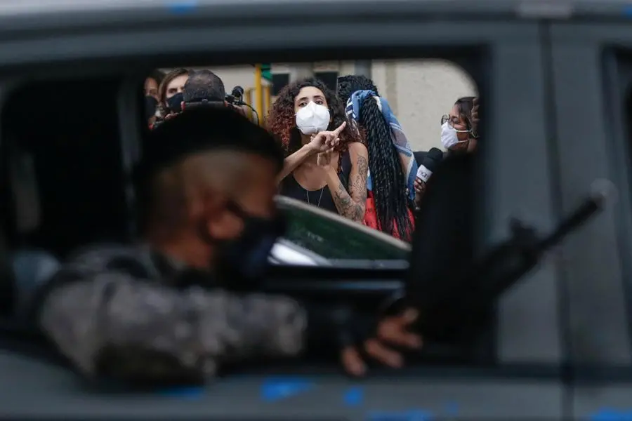 Una donna protesta contro la polizia dopo la sparatoria nella favela (EPA/ANDRE COELHO)