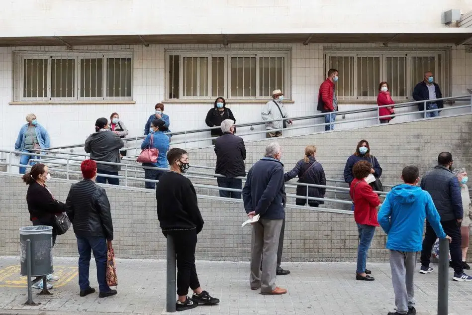 In coda per il tampone (foto Ansa/Epa)
