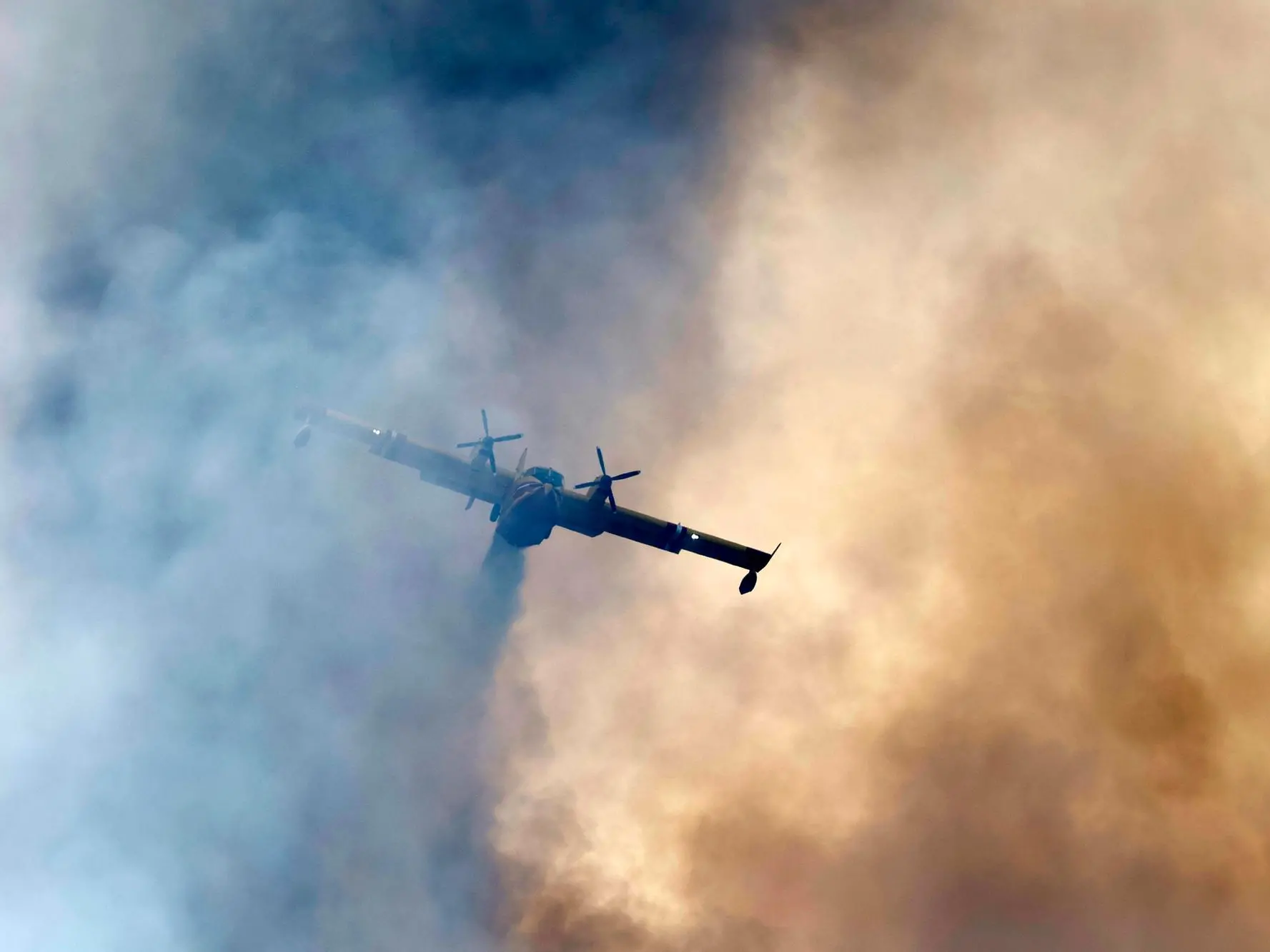 epa13127029 A Canadair aircraft drops water on a wildfire burning in Ponteves, southern France, 22 July 2026. The blaze forced scores of people to evacuate, emergency services said. EPA/SEBASTIEN NOGIER