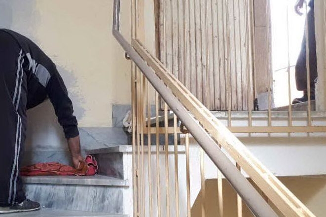 Un residente asciuga le scale di una palazzina a Santa Lucia