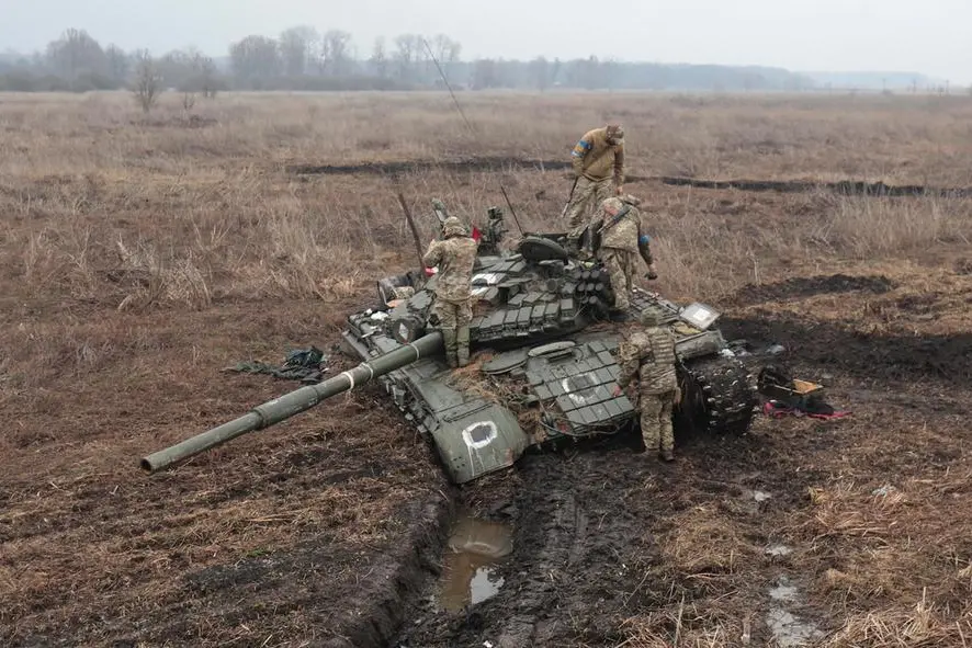 Militari ucraini ispezionano un carro armato russo (Ansa)