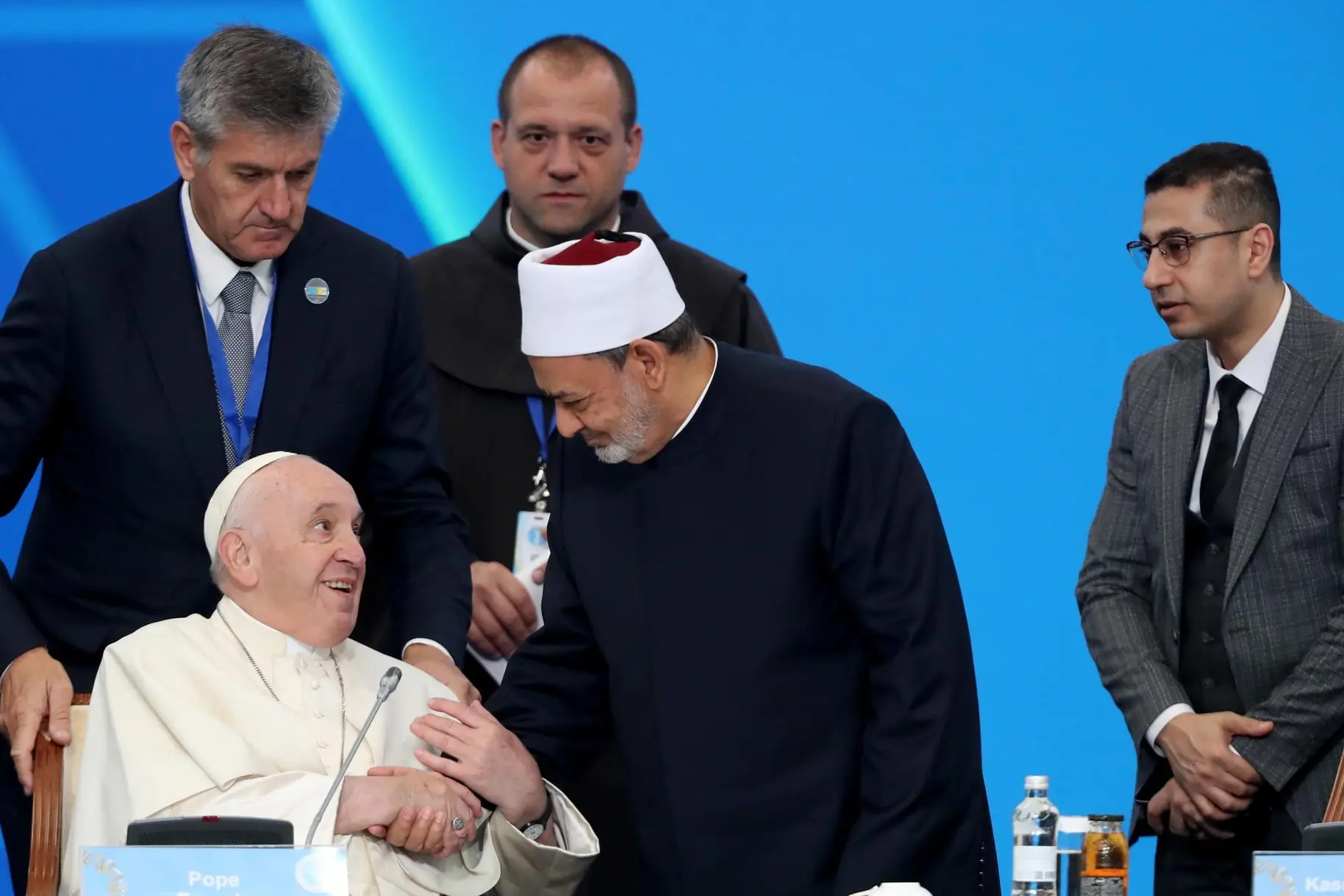 epa10182921 Pope Francis (L) is welcomed by a participant (C) as he takes his seat to attend the opening session of the VII Congress of Leaders of World and Traditional Religions in Nur-Sultan, Kazakhstan, 14 September 2022. The Pontiff on 13 September had already met with Kazakhstan's President Jomart Tokaev and will now attend the VII Congress of Leaders of World and Traditional Religions that runs from 14-15 September in the Kazakh capital. EPA/IGOR KOVALENKO