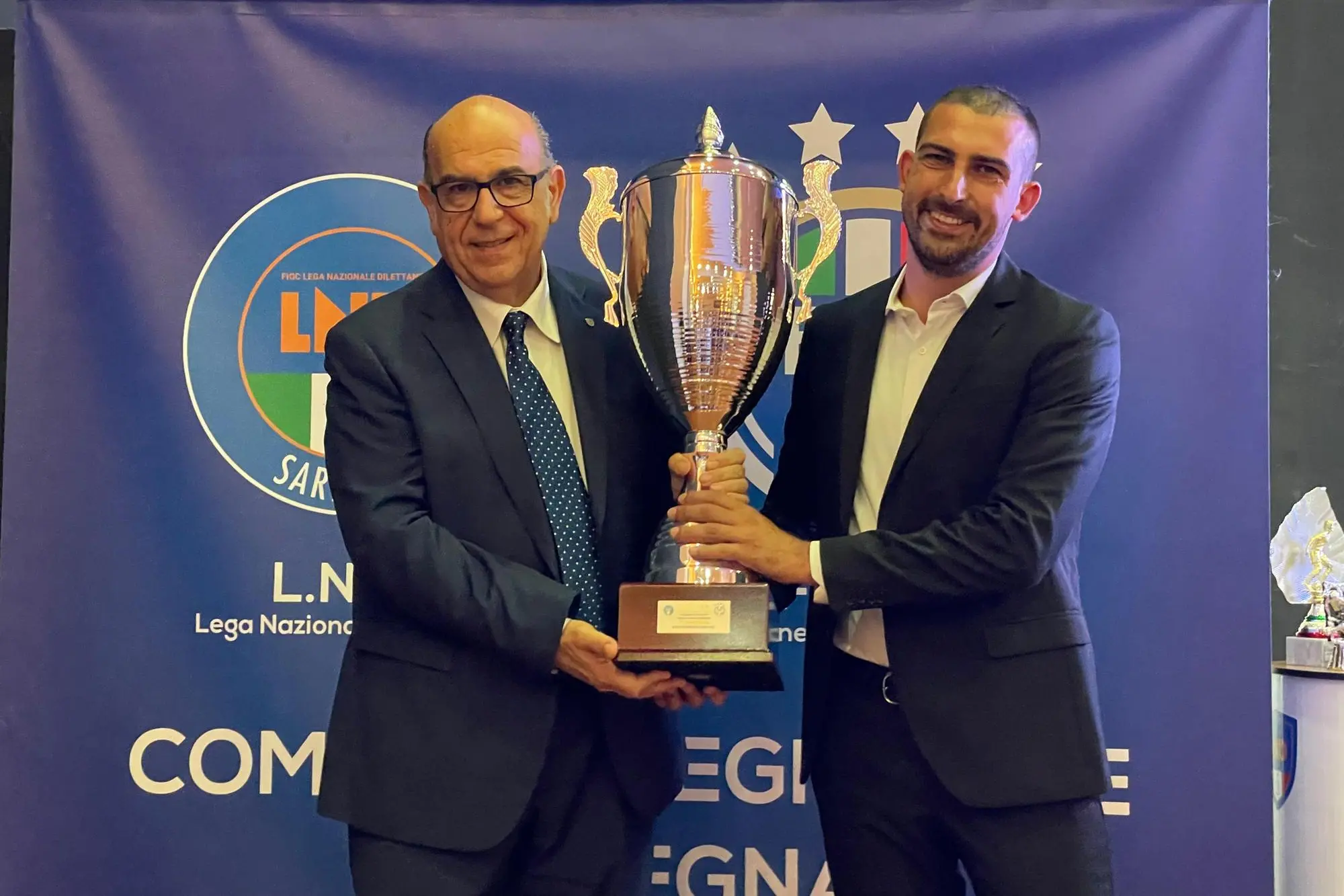 Gianni Cadoni, presidente del Comitato Regionale Sardegna (a sinistra), premia il presidente dell'Ilvamaddalena Enzo Del Giudice nella scorsa edizione del Gran Galà del calcio sardo (foto Spignesi)