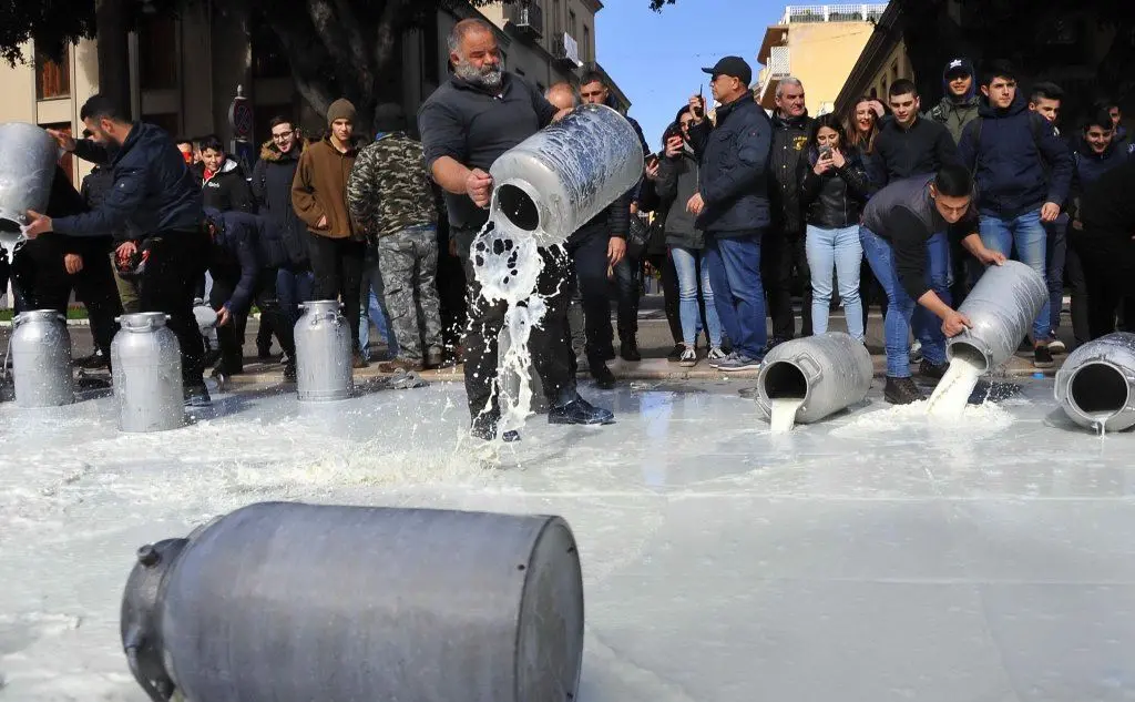 Pastori gettano latte nella fontana di piazza Roma, a Oristano