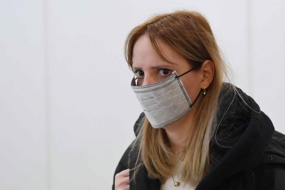 Una donna con la mascherina all'aeroporto di Londra (Ansa)