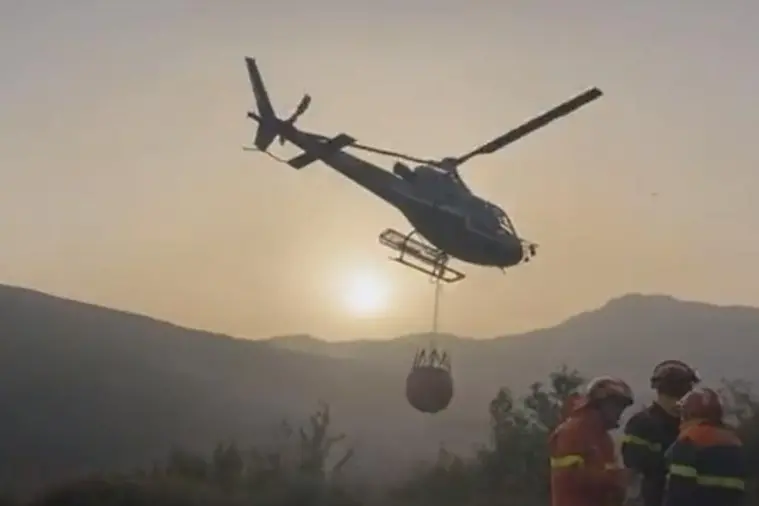 Un intervento degli elicotteri dell'ultimo appalto regionale sulle fiamme di Fonni (L'Unione Sarda)