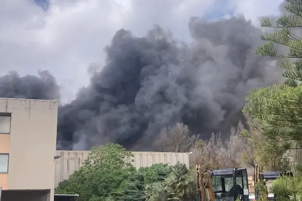 Il fuoco e la nube di fumo nell'area industriale di Porto Torres (foto Pala)