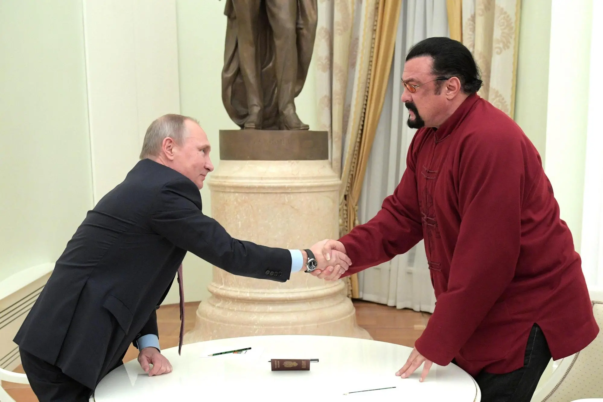 epa05647257 Russian President Vladimir Putin (L) shakes hands with US actor Steven Seagal (R) at the Kremlin in Moscow, Russia, 25 November 2016. The Russian President handed a Russian passport to Seagal and congratulated him on receiving Russian citizenship. EPA/ALEXEI DRUZHININ / SPUTNIK / KREMLIN POOL/POOL